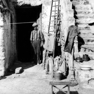 sei-su-immagine-raffigurante-un-anziano-abitante-dei-Sassi-sull-uscio-della-propria-casa-grotta