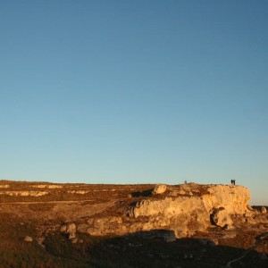 sei-su-immagine-raffigurante-un-tramonto-estivo-tinge-di-arancio-una-rupe-della-gravina-di-matera